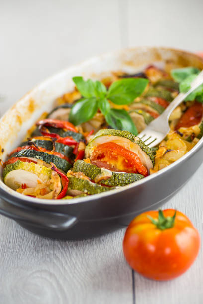 istock prepared baked zucchini and tomatoes in circles in a ceramic form, vegetable snack 2165547634