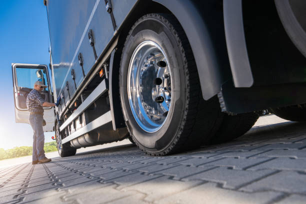 istock Trucker Inspecting Semi-Trailer Tire 2165549343