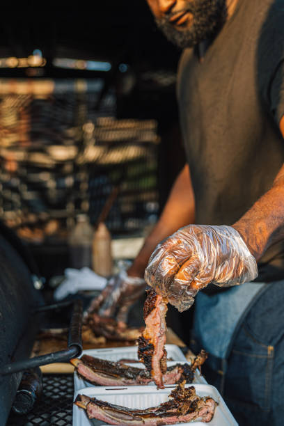 istock Chef wearing plastic gloves Filling Compostable Take-Out Containers with Pork Ribs for his Food Truck or Catering Company 2165553706