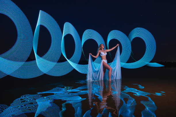 istock Young slim girl posing in water with abstract blue light effect 2165556200