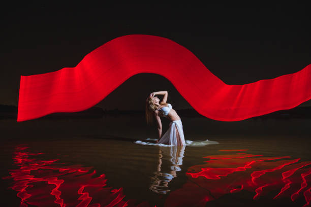 istock Young slim girl posing in water with abstract red light effect 2165556257