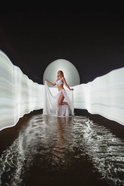 istock Young slim girl posing in water with abstract light effect 2165556286