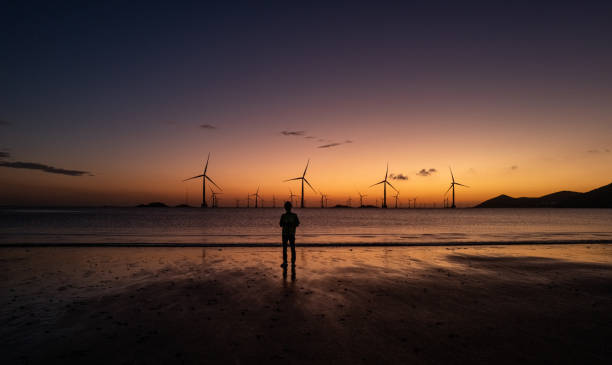 istock Electricians at an offshore wind farm work on the beach at dawn 2165556379