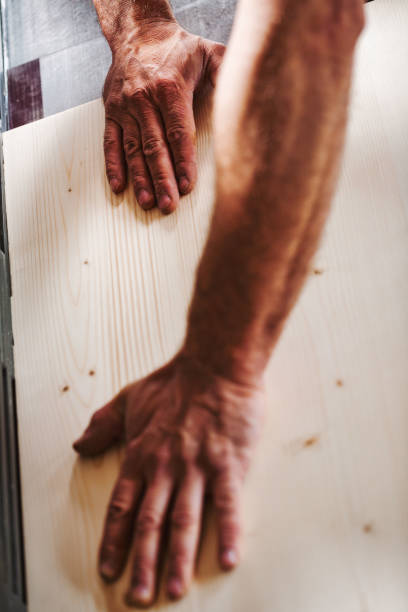 istock Carpenter touching wooden plank in workshop 2165557135