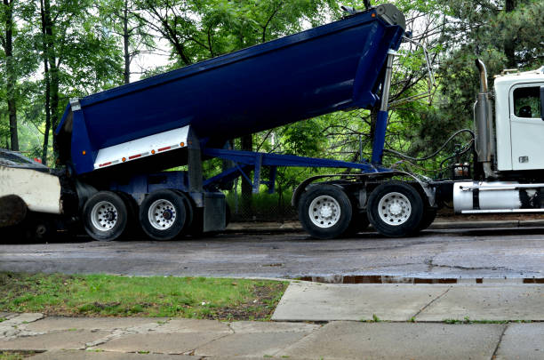Pavement machine laying fresh asphalt with loading truck