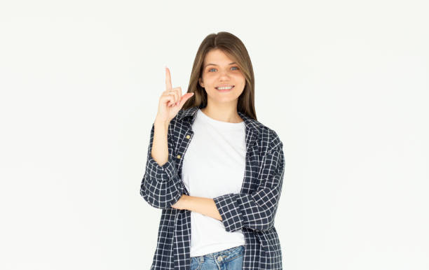 istock Smiling woman pointing finger up over white background 2165558259