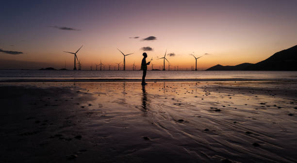 istock Electricians from offshore wind farms work on the beach at dawn 2165558417
