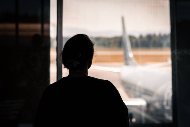 istock Traveler Watching Airplane Through Airport Window 2165559200