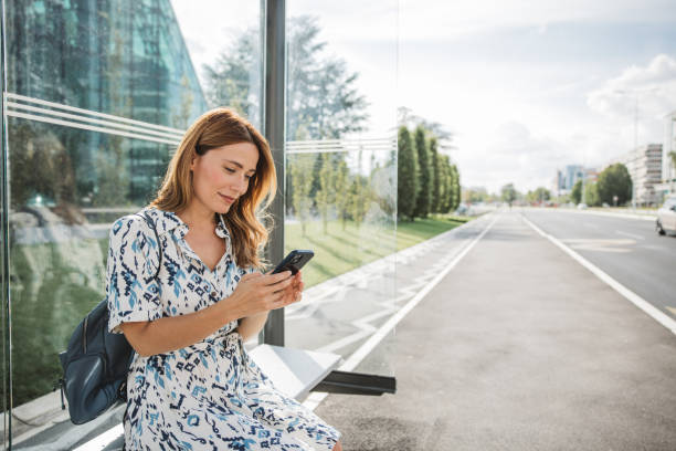 istock Waiting for bus and online investing 2165560152