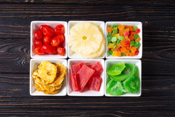 Various tropical fruits, cut into small pieces, are arranged and packed in a take-away plastic box, ready for sale at a market stall.