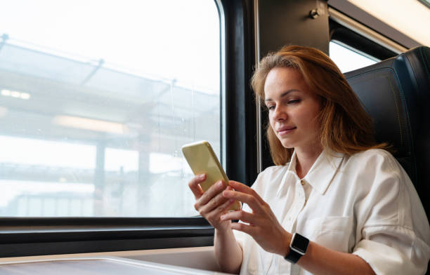istock Modern tech-savvy businesswoman messaging online with her smartphone while traveling for work by train. Work on the go. 2165563347