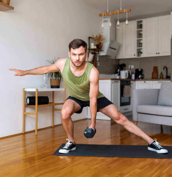 istock Young adult man doing home workout using dumbbells. 2165563684