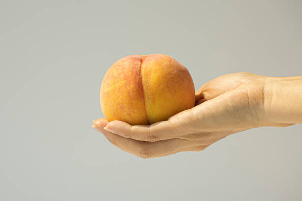 istock delicious yellow peaches in hand 2165566163