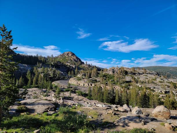 istock Ccenic mountain landscape with a winding road, pine trees, and a clear blue sky 2165571403