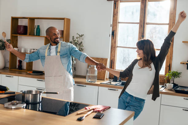 istock Lovely attractive couple dancing while cooking in the kitchen at home 2165572496