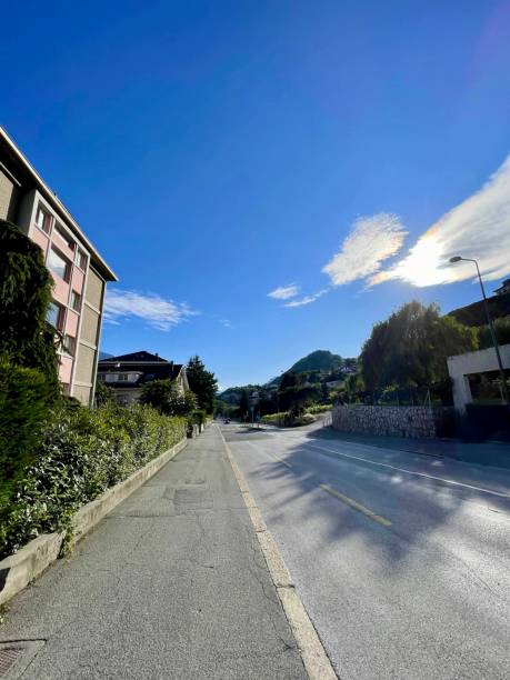 istock Road in the mountains under clear blue sky with buildings 2165574543