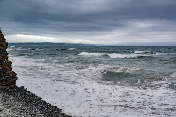 Sandymouth Cornwall on a cold August morning with storm clouds at high tide