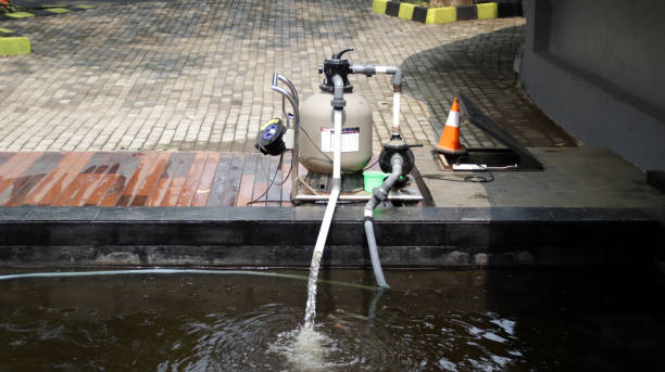 istock Outdoor Water Pump System Filtering Pond Water with Orange Safety Cone and Brick Pathway Background in Bright Daylight 2165579956