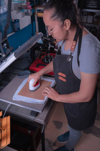 istock Working woman in her workshop doing the sublimation process with a heat press. 2165580006