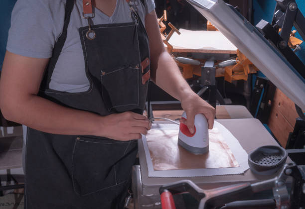 istock Working woman in her workshop doing the sublimation process with a heat press. 2165580429