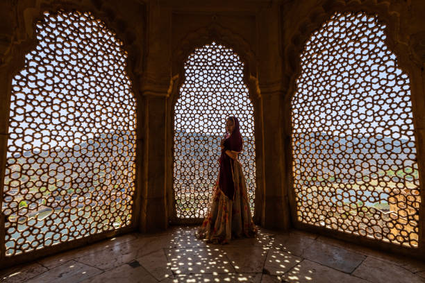istock Young Indian woman looking through the window 2165582720