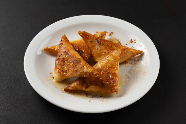 istock Mini cheese pies with myzithra, cretan honey and cinnamon on white plate. 2165586397