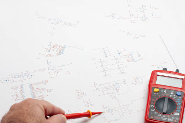 istock Engineer's desk with electronic blueprints and a multimeter. 2165588490