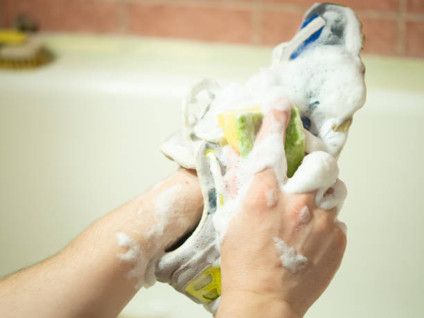istock man washes sneakers with a brush 2165590469