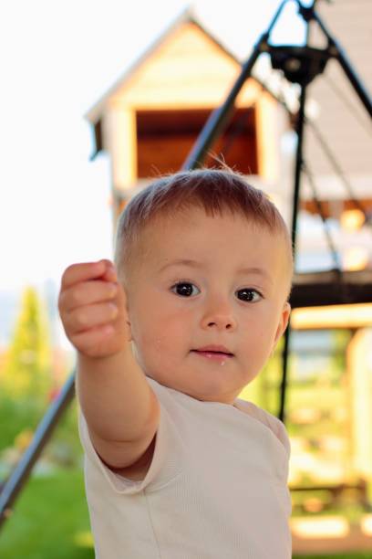 Portrait of a small child stretching his hand forward, showing something