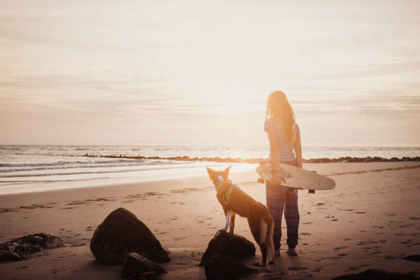 istock Young woman vacations at beach, with dog 2165596176