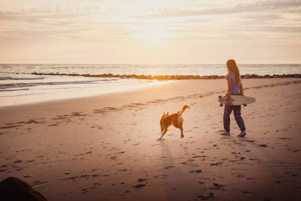 istock Young woman vacations at beach, with dog 2165596183