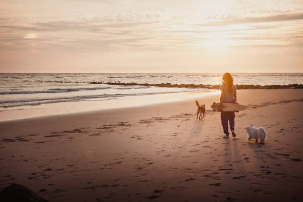 istock Young woman vacations at beach, with dog 2165596190