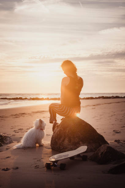 istock Young woman vacations at beach, with dog 2165596196