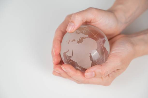 istock Crystal globe in female hands on a white background. 2165596855