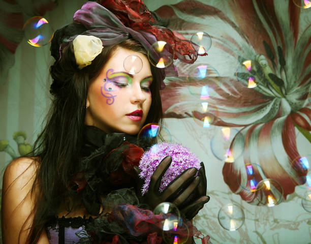 istock fashion model with creative make-up blowing soap bubbles. 2165597018