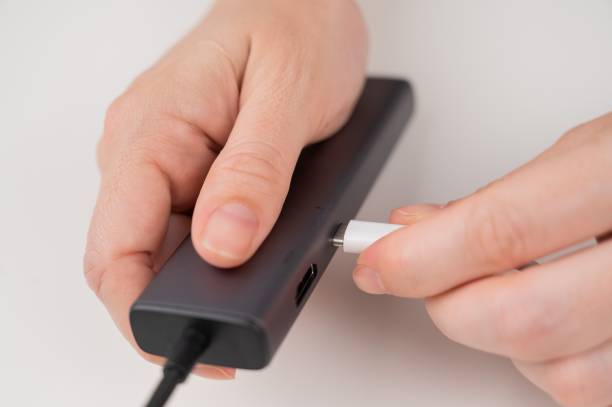 istock A woman inserts a white Type C cable into a black port. 2165606455