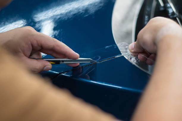 istock The master in the car service cuts the protective cutter. 2165606587