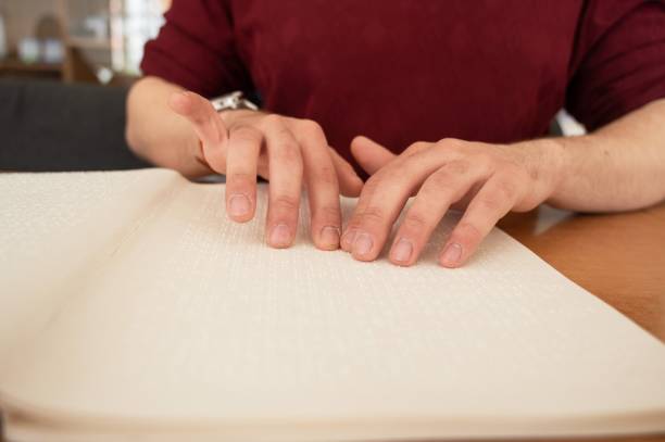 istock Visually impaired man reading a braille book. 2165622720