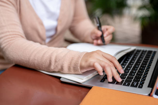 istock A woman pressing the Enter button to pause a video while studying an online class on her laptop. 2165623920