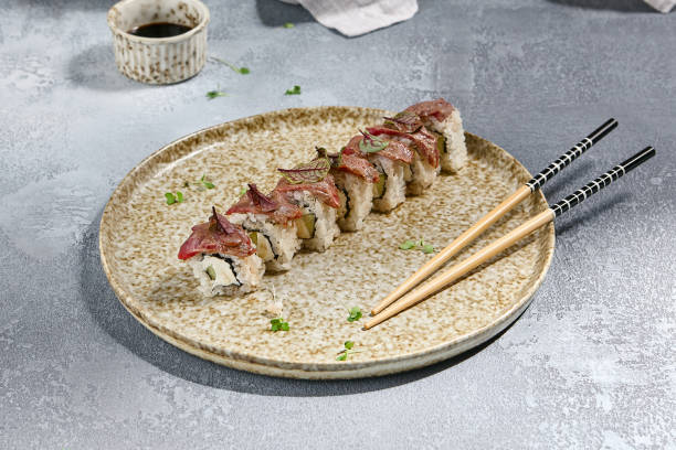 istock Delicious Seared Beef Sushi Roll with Roast Beef Topping on a Ceramic Plate 2165624308