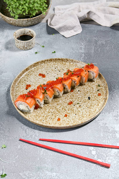 istock Sushi Roll with Salmon and Red Caviar on Ceramic Plate 2165624357