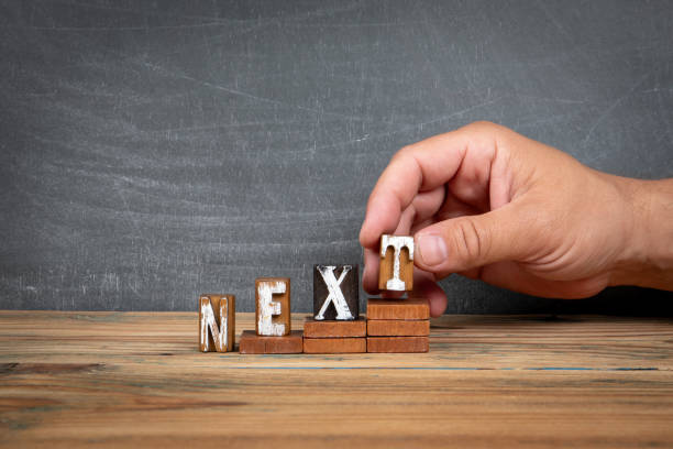 istock NEXT. Wooden letters, alphabet blocks on steps. development and growth concept 2165626721