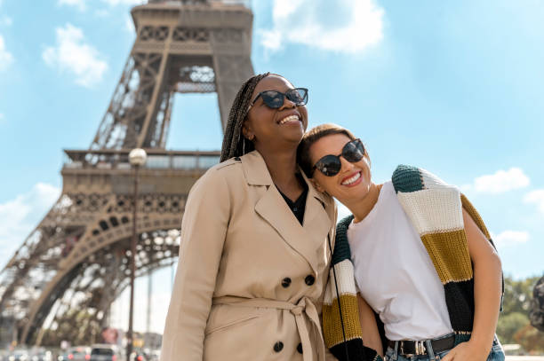 istock Cheerful young multiethnic girlfriends laughing, standing close together with Eiffel Tower in background 2165626790