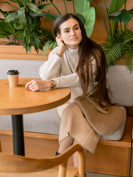 istock Brunette woman sitting in cafe and drinking coffee 2165629799