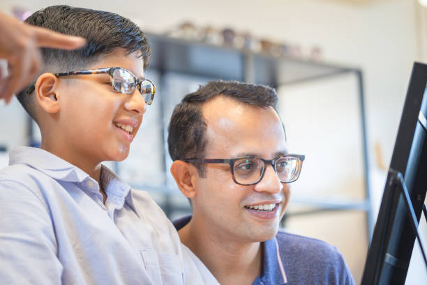 istock Indian father and son choosing eyeglasses in optics store 2165630405