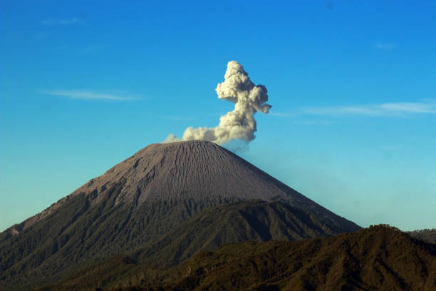 Tourists exploring the beautiful landscape of Ijen volcano and looking at the scenic blue fire and yellow sulfur smoke during sunrise on java island, Indonesia