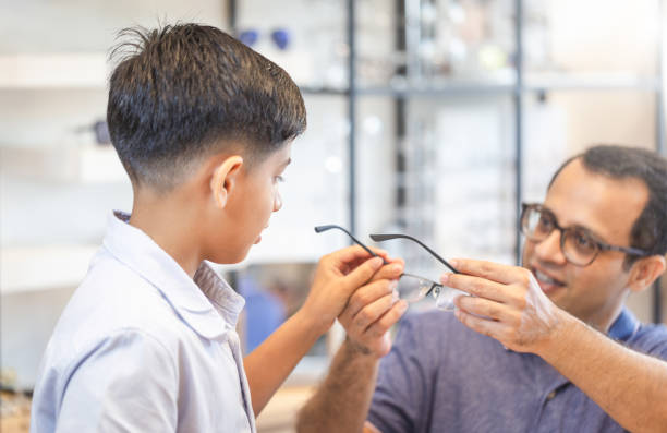 istock Indian father and son choosing eyeglasses in optics store 2165635483