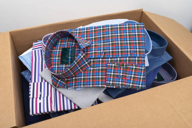 istock Full cardboard box of various shirts, close up 2165638517