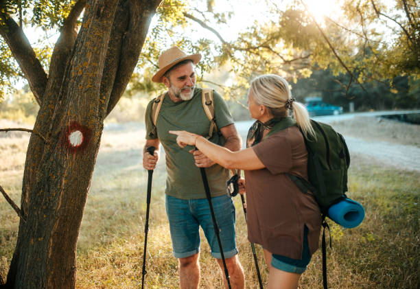istock senior  couple hiking behind marking on tree 2165638999