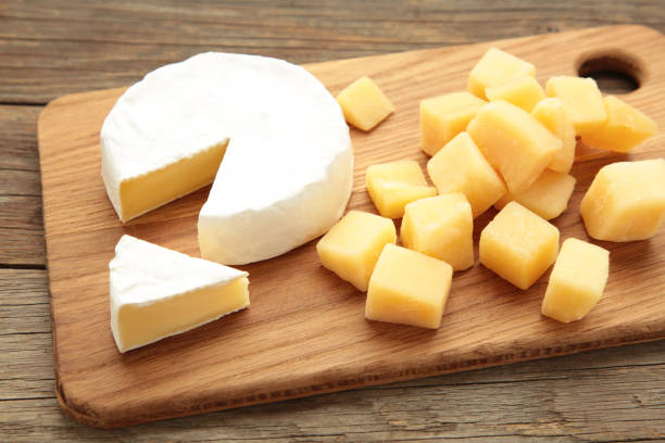 istock Parmesan cheese with camembert on cutting board. 2165642299